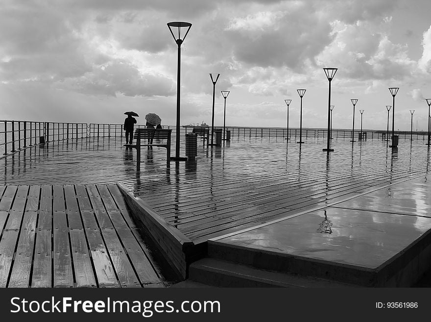 Tourist On Rainy Boardwalk In Black And White