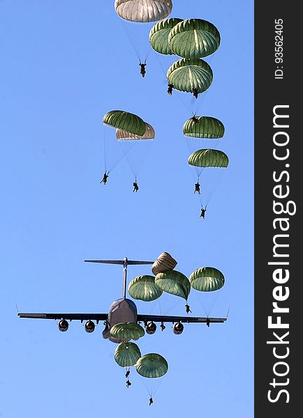 Army Paratroopers Practicing Parachute Drop from a Military Air Plane during Daytime