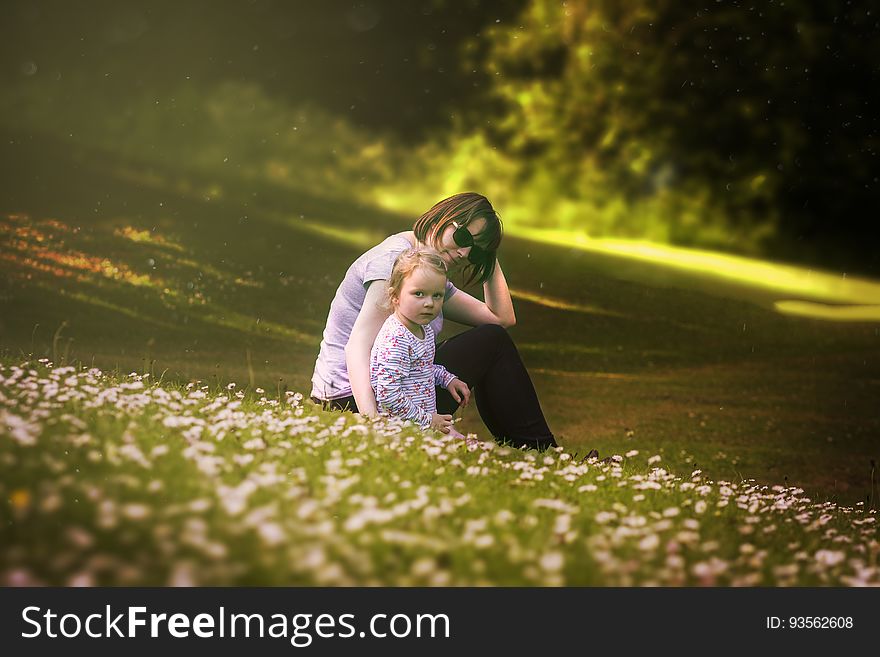 Portrait of mother with young daughter in field of wildflowers on sunny day. Portrait of mother with young daughter in field of wildflowers on sunny day.