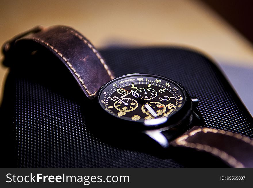 Close up of wristwatch with leather strap on smartphone. Close up of wristwatch with leather strap on smartphone.