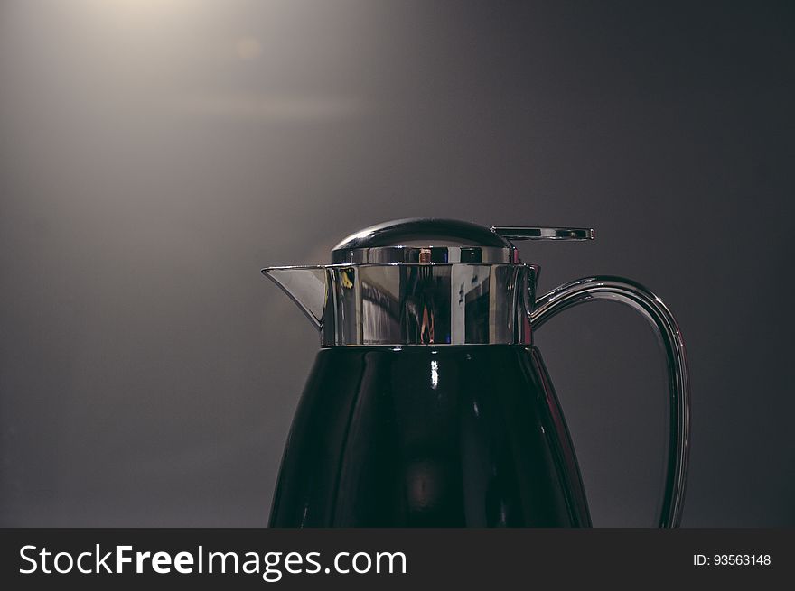 Close up of coffee carafe with metal handle.