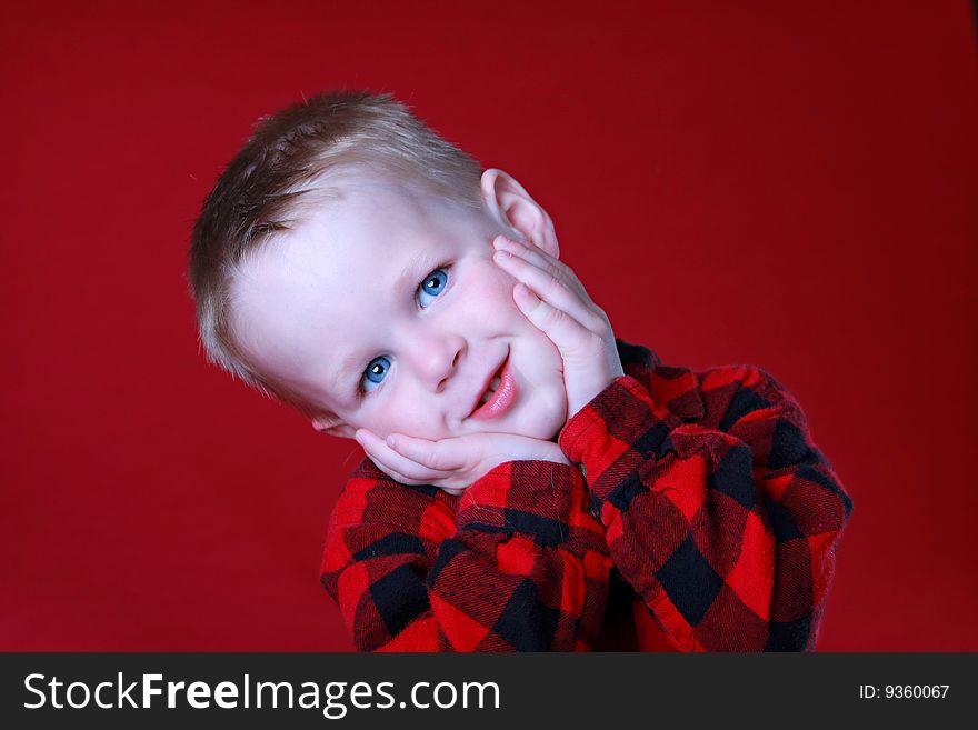 Cute expression on Boy, in Red Flannel, or Red background, blue eyes. Cute expression on Boy, in Red Flannel, or Red background, blue eyes