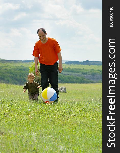 Father and son playing with ball outdoors