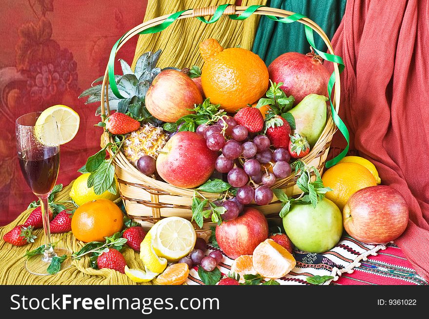 Background with red grape,
apple, orange,pomegranate,
pineapple in basket. Background with red grape,
apple, orange,pomegranate,
pineapple in basket
