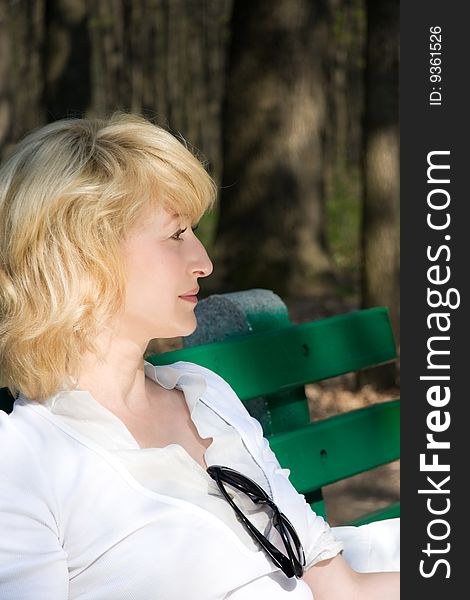 Beautiful blond woman sitting outdoors. Beautiful blond woman sitting outdoors