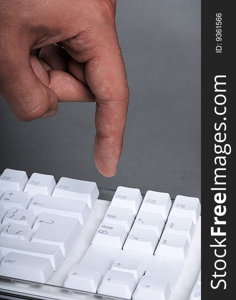 Vertical image of male hand on the white keyboard of computer