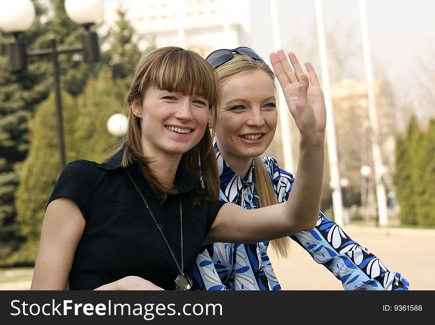 Women sitting on the bench and greet someone. Women sitting on the bench and greet someone