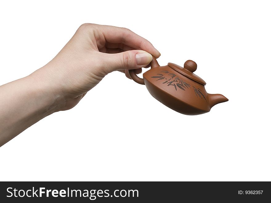 Woman hand with a little clay teapot isolated on white background