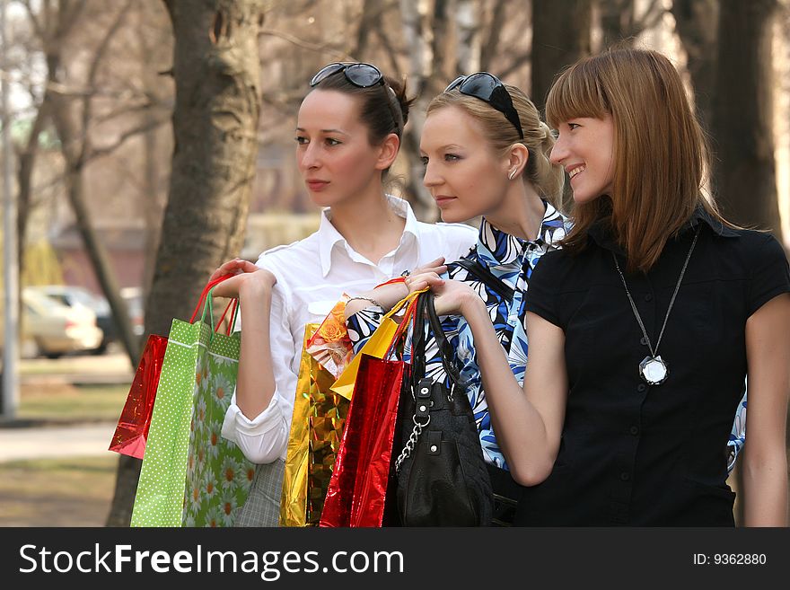 Women posing with bags after shopping in a city. Women posing with bags after shopping in a city