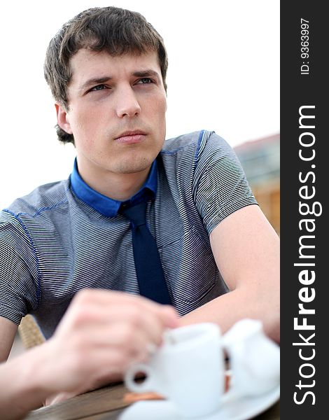 Young man drinks coffee outside. Young man drinks coffee outside.