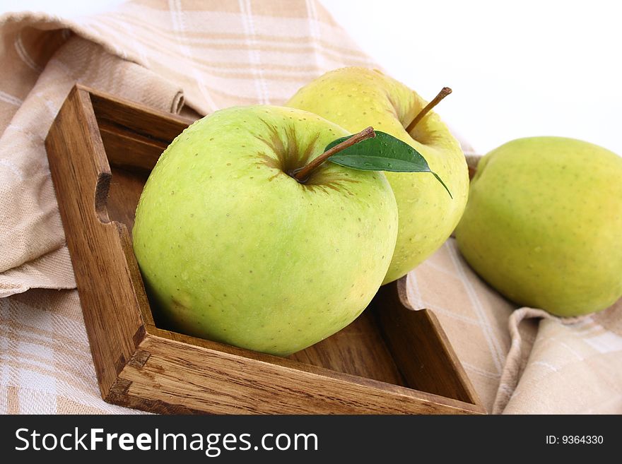 Three green apples on square dish isolated on white