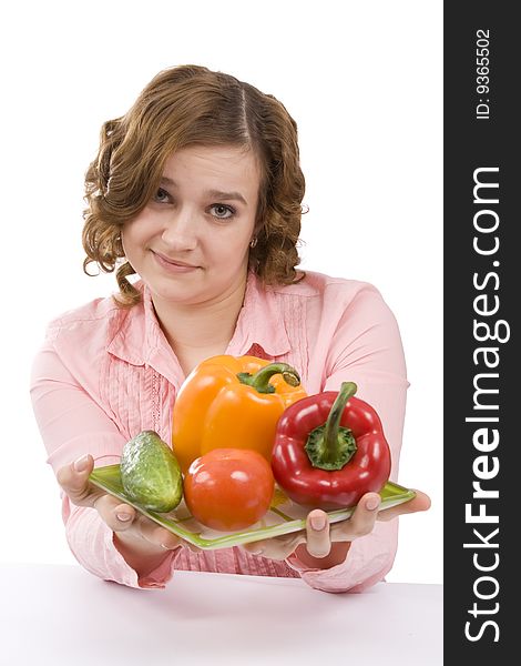 Housewife is holding the plate with pepper, tomato, cucumber. Pretty girl with fresh vegetables. Isolated over white background. Housewife is holding the plate with pepper, tomato, cucumber. Pretty girl with fresh vegetables. Isolated over white background.