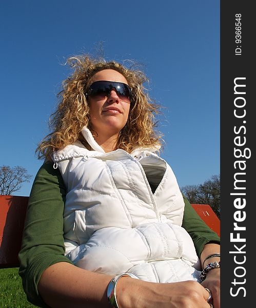 Curly girl with sunglasses in white vest