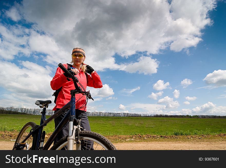 Girl with bike in green summer field. Girl with bike in green summer field