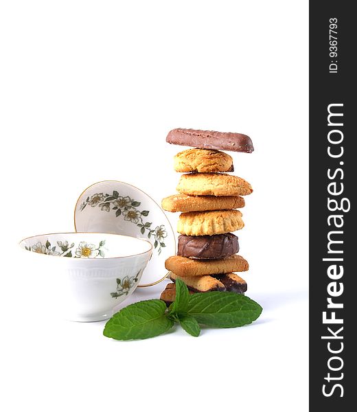 Pile of biscuits and tea cups on white background. Pile of biscuits and tea cups on white background