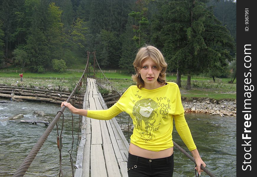 Beautiful girl on a bridge in a yellow blouse