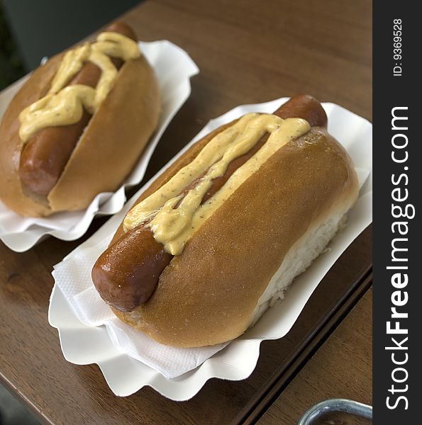 Nice shot of a couple of hot dog served on carton plates. Nice shot of a couple of hot dog served on carton plates