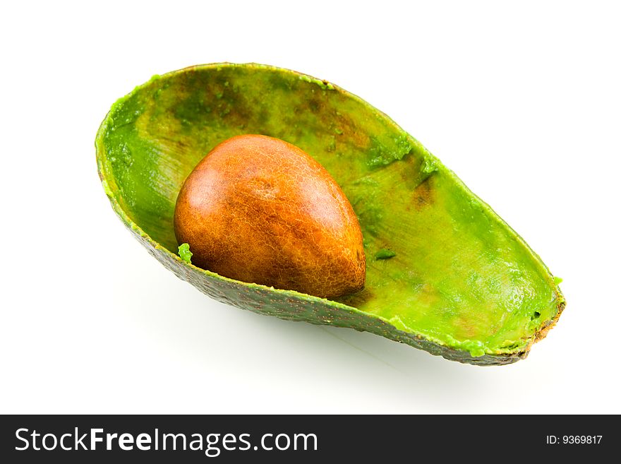 Single dark green avocado fruit split in half scooped out and showing the kernel on a white background. Single dark green avocado fruit split in half scooped out and showing the kernel on a white background