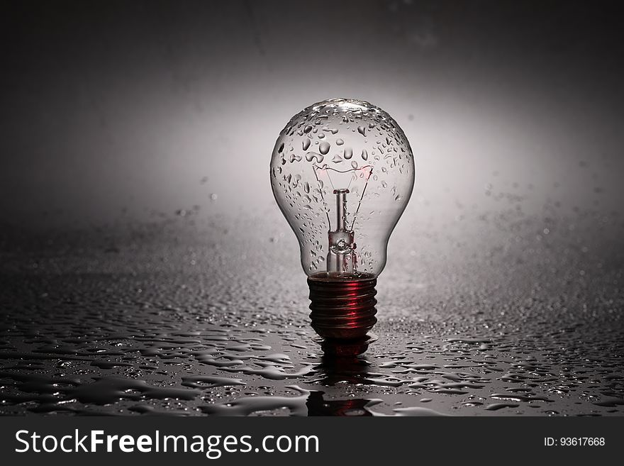 Close up of vintage incandescent light bulb in water with drops. Close up of vintage incandescent light bulb in water with drops.