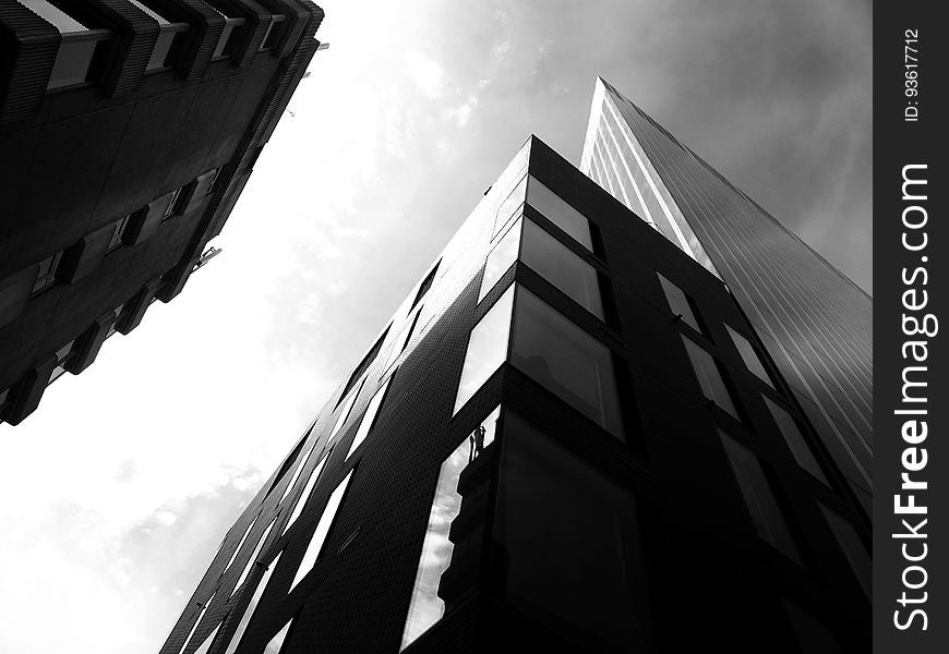 Facade of modern architecture against cloudy skies in black and white. Facade of modern architecture against cloudy skies in black and white.
