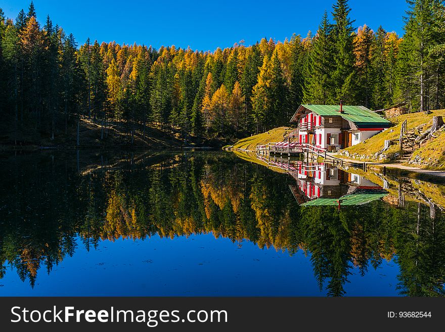 Lake House Reflecting In Calm Waters