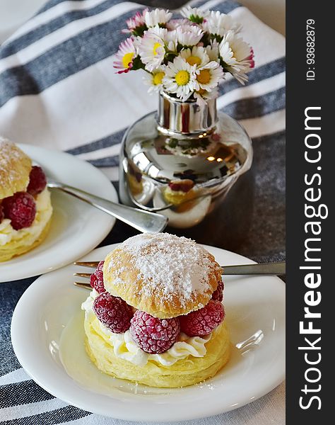 Cream puff with raspberries on table.