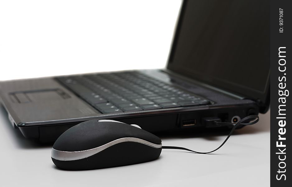 A laptop computer with an attached mouse