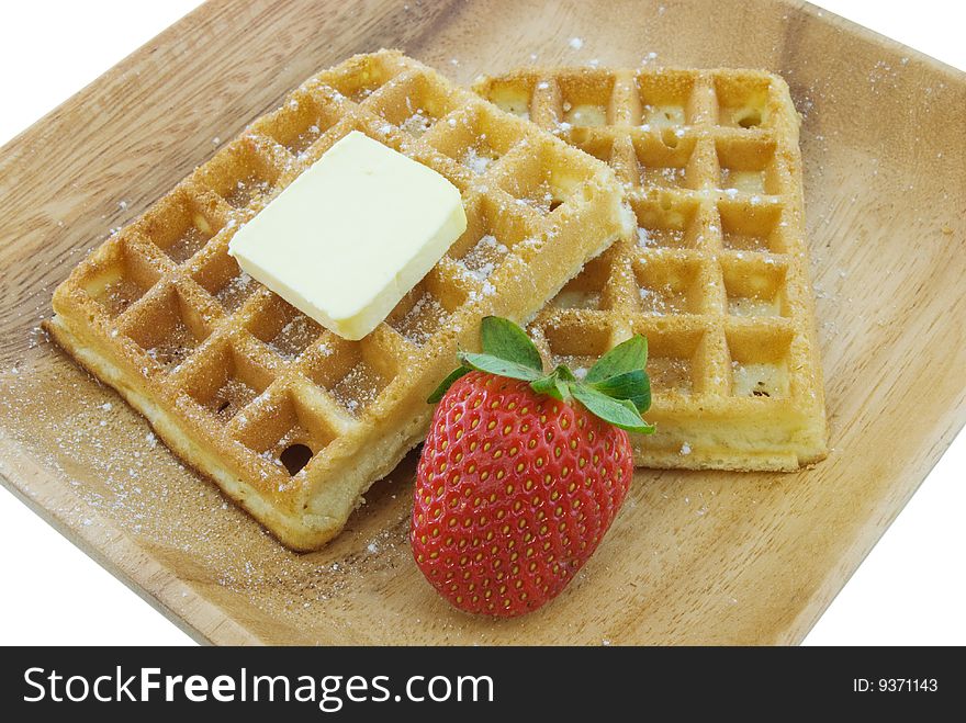 Two waffles on plate with strawberry and butter