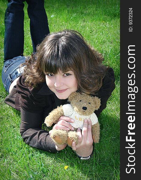 Girl with teddy on the grass. Girl with teddy on the grass