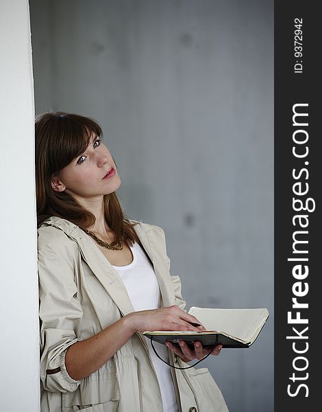 young woman stands writes in book. young woman stands writes in book