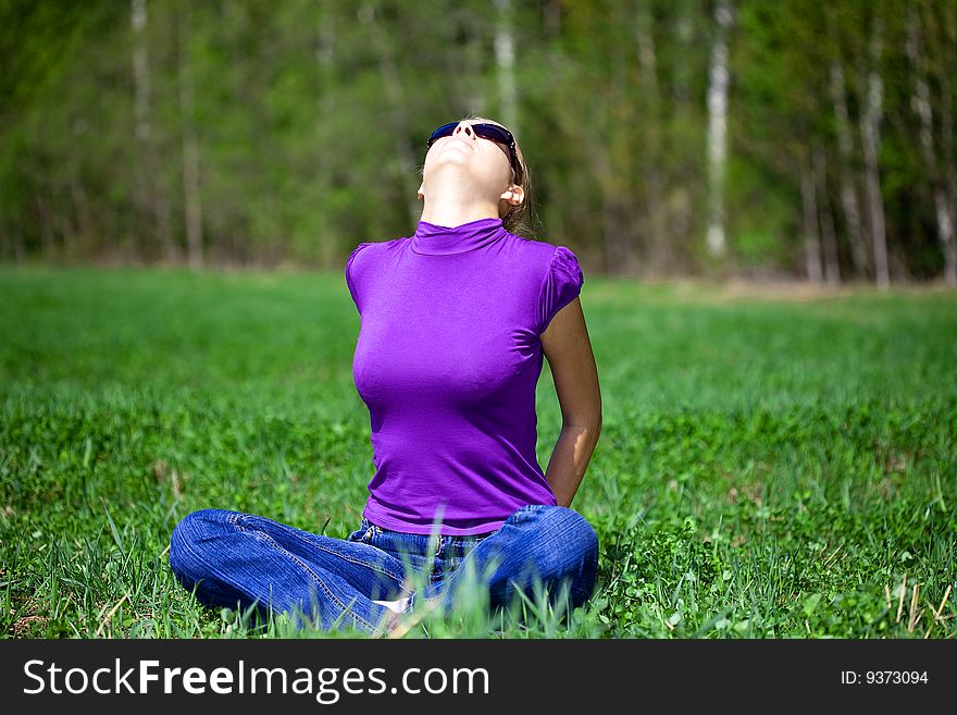 Beautiful woman sitting in the grass and Enjoy the sun. Beautiful woman sitting in the grass and Enjoy the sun