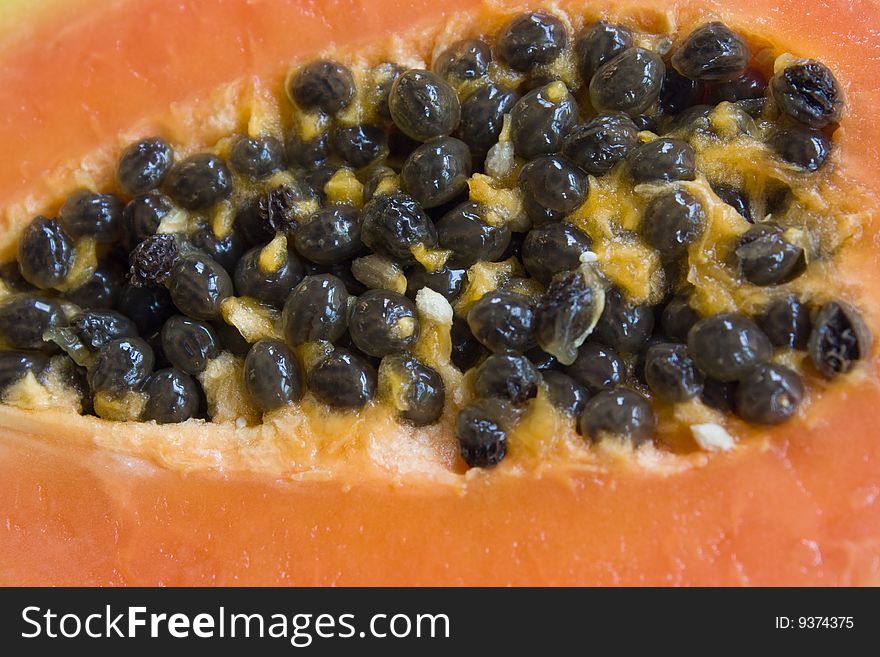 A papaya cut in half with the seeds in the centre. A papaya cut in half with the seeds in the centre