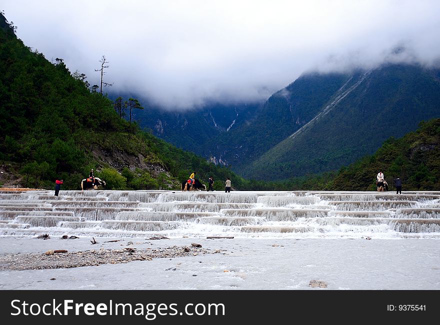 At yulong snow mountain whiteriver,some tourists Photographic photos of riding a yak. At yulong snow mountain whiteriver,some tourists Photographic photos of riding a yak