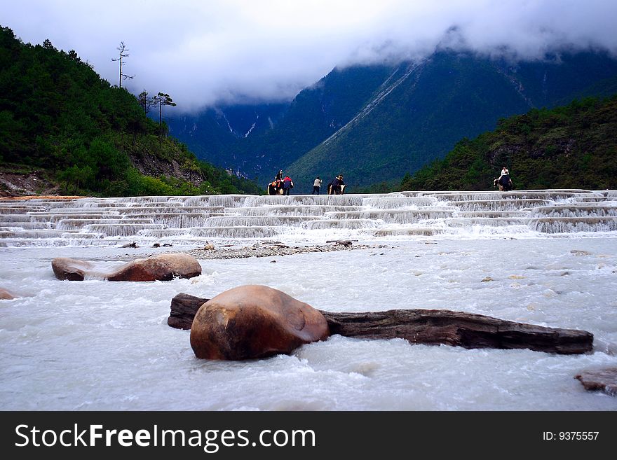 At yulong snow mountain whiteriver,some tourists riding yaks. At yulong snow mountain whiteriver,some tourists riding yaks