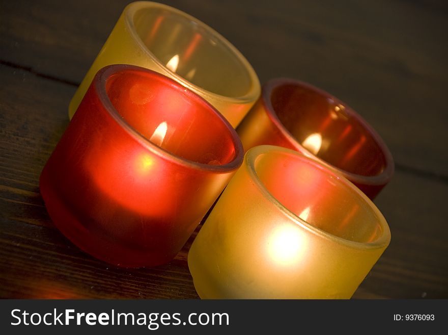 Four colorful candles on the wood background