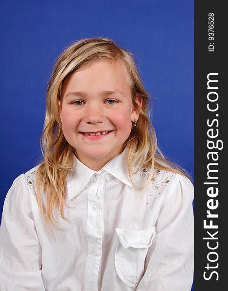 Portrait of a cute happy smiling girl on blue background