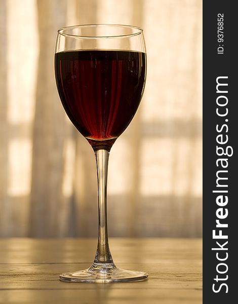 Glass of red wine in front of the window. Glass of red wine in front of the window