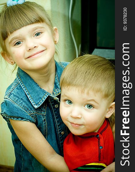 Two siblings embrace each other and laughing happily.