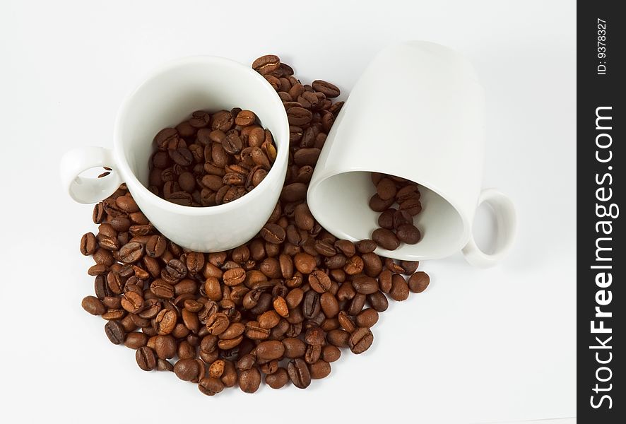 Coffee beans and cups, white background