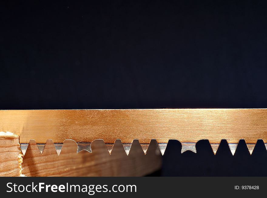 Detail of a blade of a hand saw in a piece of wood