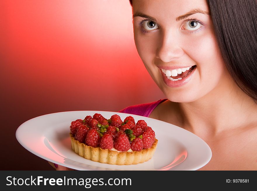 Happy Young beautiful woman with raspberry cake