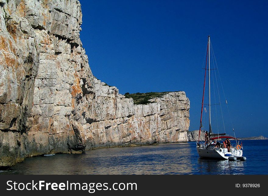 The yacht on calm sea near by rock. National park in Croatia.