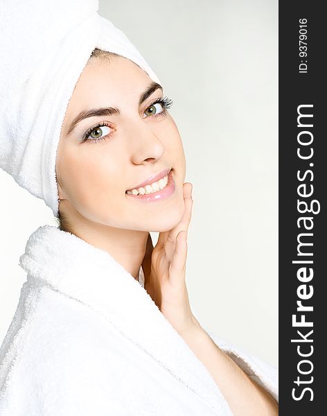Portrait of a pretty girl wrapped into the white towel applying cosmetics. Portrait of a pretty girl wrapped into the white towel applying cosmetics