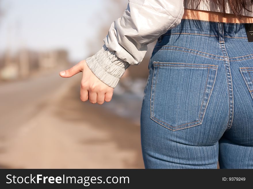 Women is hailing a car on a road. Women is hailing a car on a road