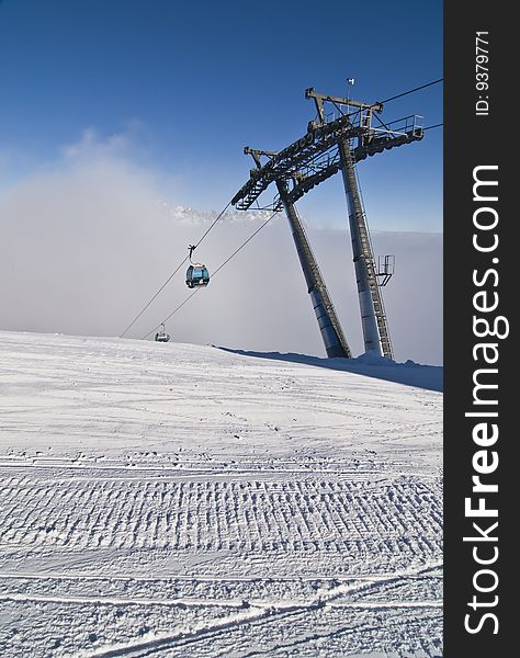 Groomed snow and ski lift with gondola