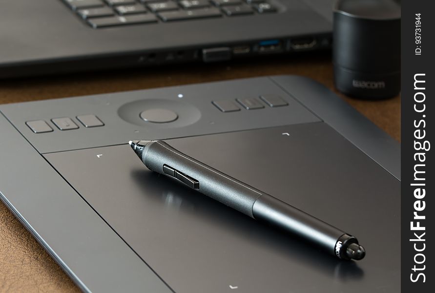 A close up of a black pen on a tablet. A close up of a black pen on a tablet.