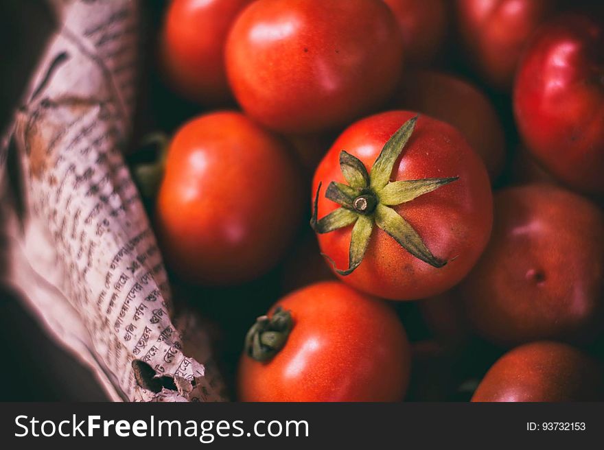 Close up of fresh ripe red tomatoes in bowl lined with papers. Close up of fresh ripe red tomatoes in bowl lined with papers.