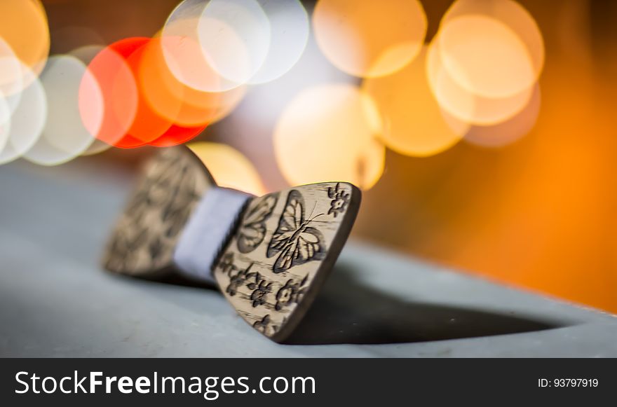 Closeup of wooden carved bow with butterfly shapes, bokeh lights in background. Closeup of wooden carved bow with butterfly shapes, bokeh lights in background.