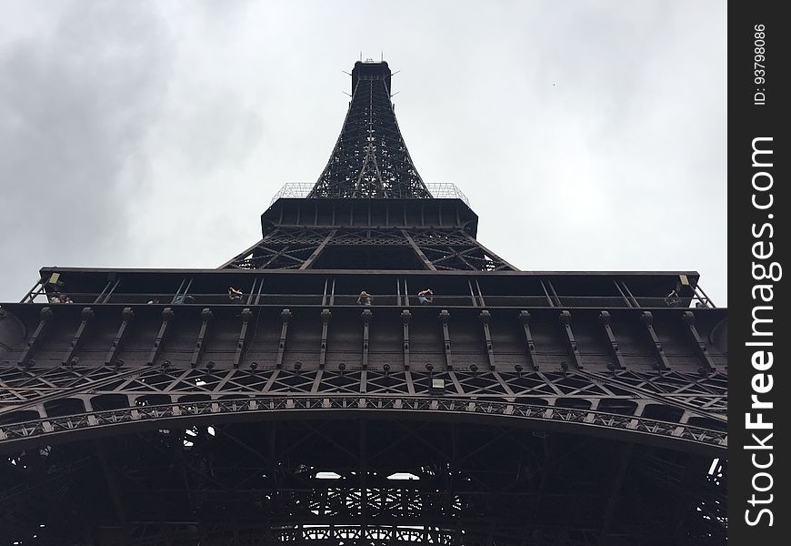 Underneath the Eiffel Tower in Paris, France with overcast skies. Underneath the Eiffel Tower in Paris, France with overcast skies.