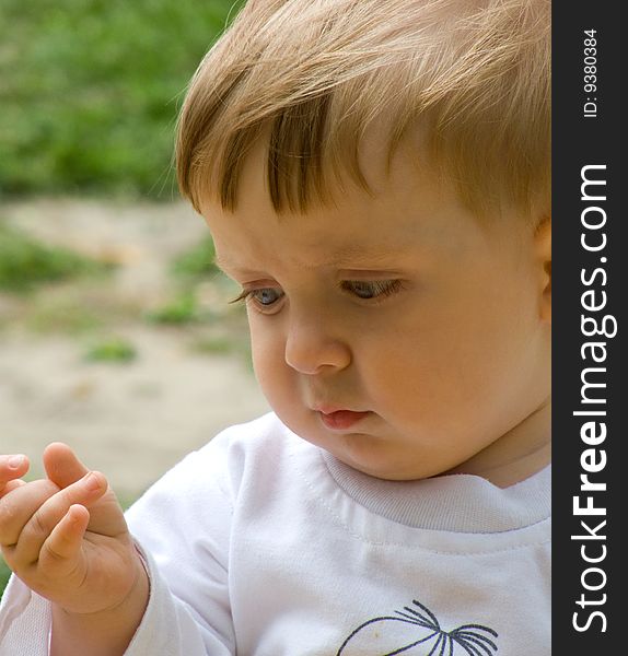 Serious baby-boy in white t-shirt on walk